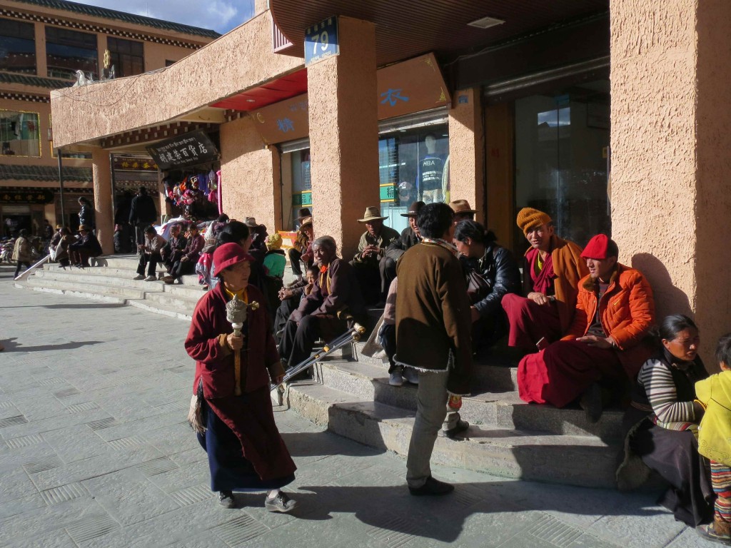 The devout Tibetan buddhists go about swinging mobile prayer wheels.